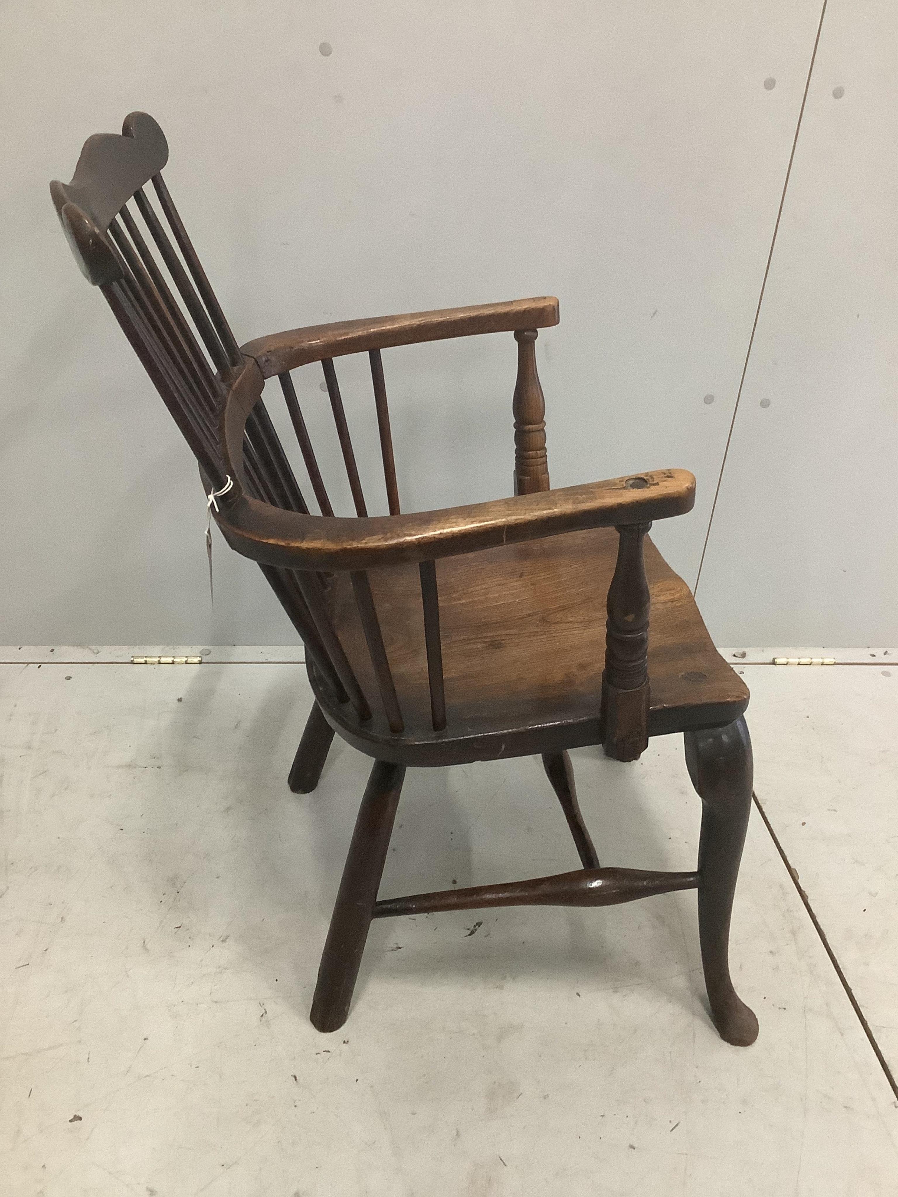 An early 18th century ash and elm primitive Windsor elbow chair on cabriole front legs, width 52cm, depth 43cm, height 89cm. Condition - fair